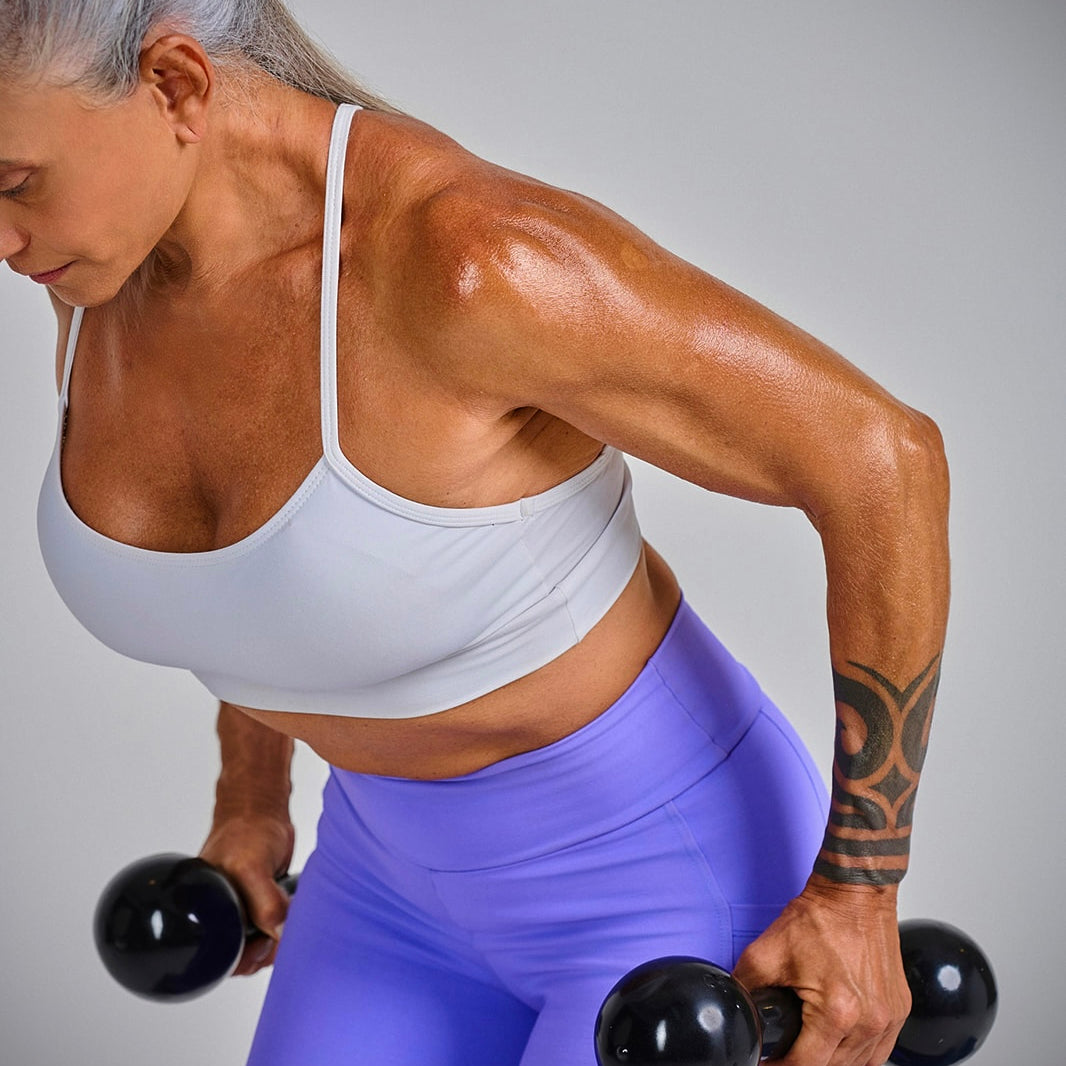 Midlife woman performing strength training with dumbbells, highlighting the importance of muscle for healthy aging.