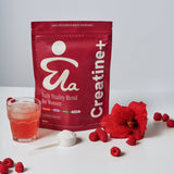 ByEla supplement package labeled 'Creatine+' with a glass of red liquid, raspberries, and a flower on a white background.
