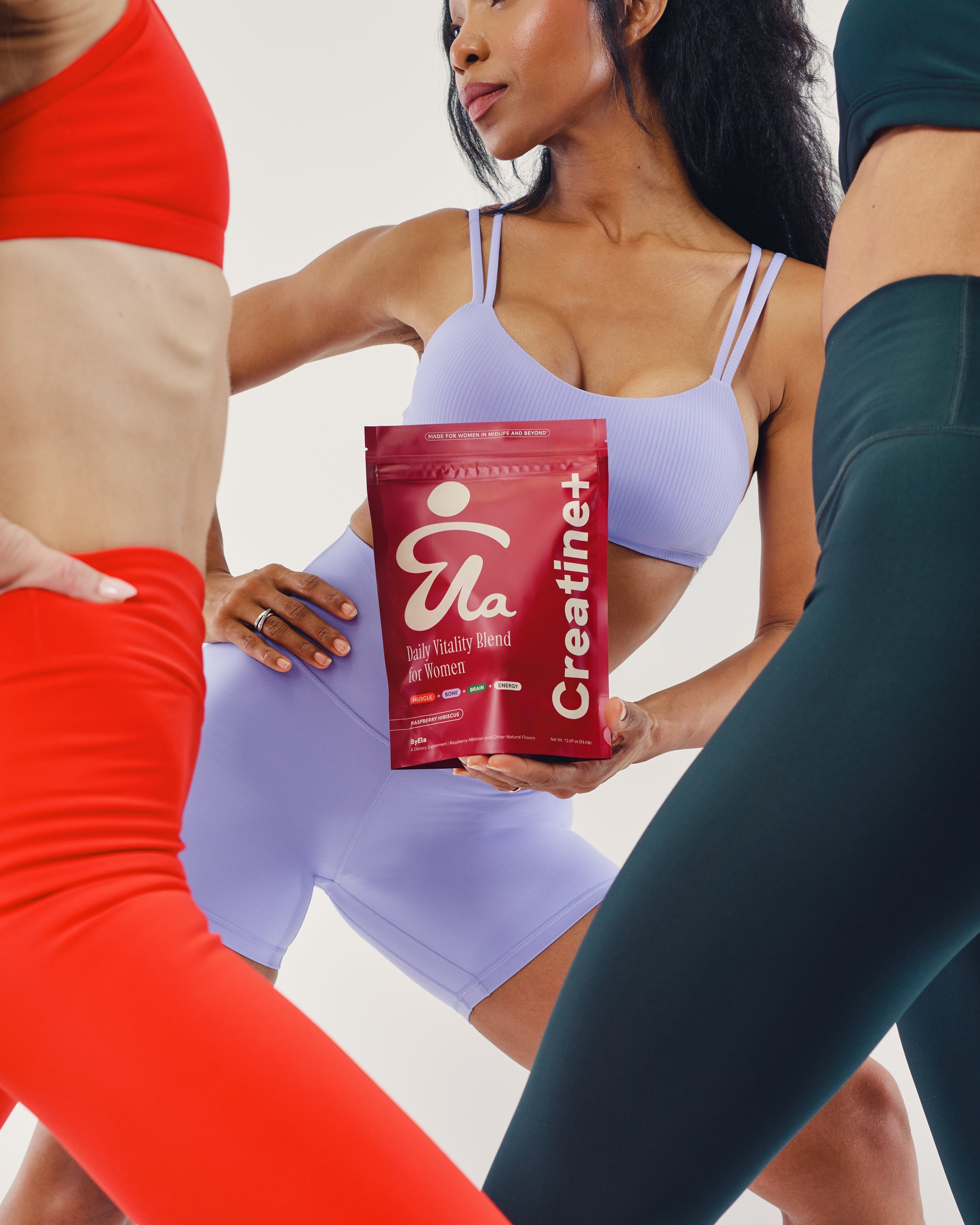 Women in activewear holding ByEla Creatine+ Daily Vitality Blend, highlighting strength and confidence after 40.