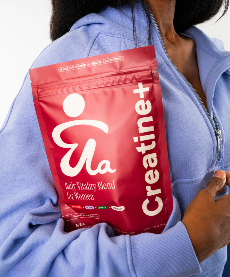 Woman holding ByEla Creatine+ supplement pouch against her chest, symbolizing confidence and daily wellness for women over 40.